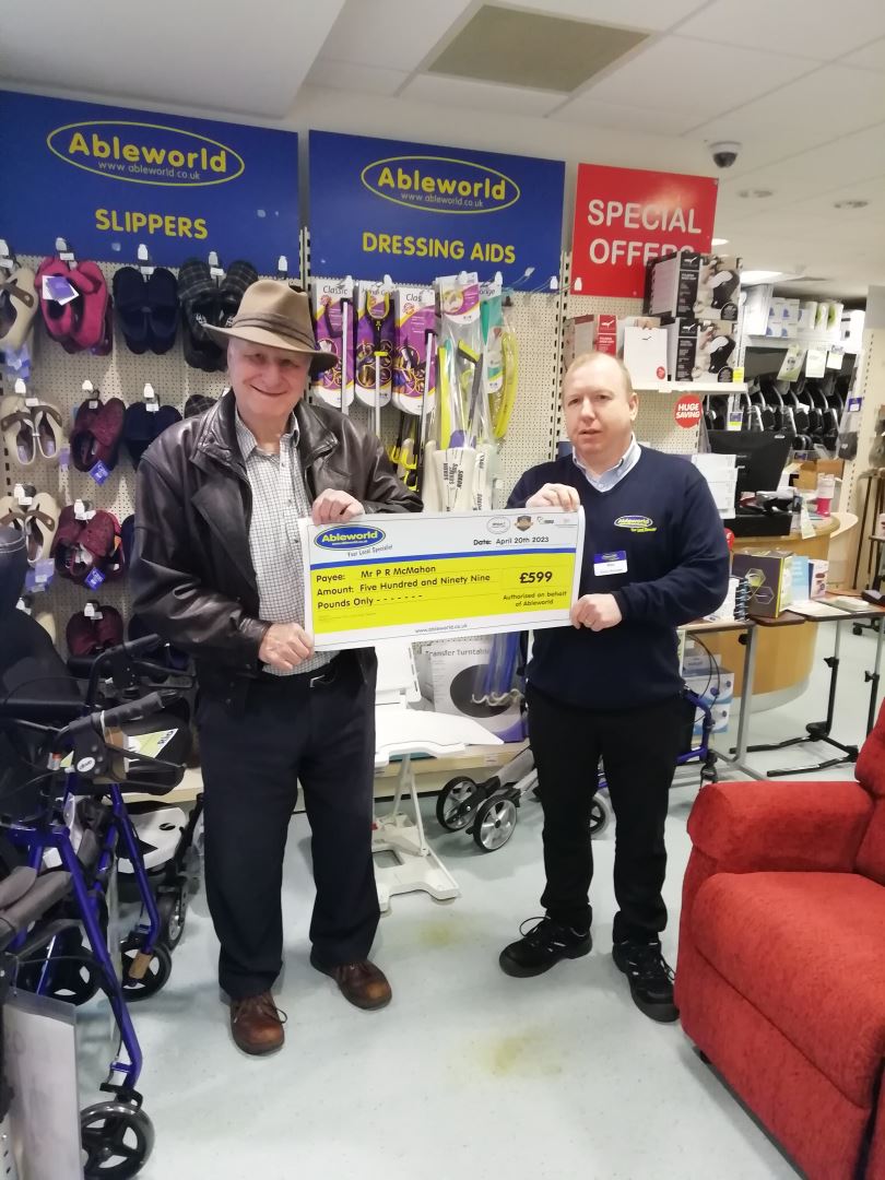 Store Manager Mike from Ableworld Oswestry handing his winning customers cheque for his money back on his riser recliner chair 